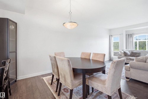 Open concept room with dark wood-finish flooring, white walls, and a contemporary ceiling light fixture - #22 723 172 Street Sw, Edmonton, AB - Indoor Photo Showing Dining Room