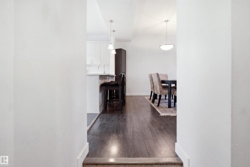 Open concept interior featuring dark wood-finish flooring, white baseboards, and bright white walls - #22 723 172 Street Sw, Edmonton, AB - Indoor Photo Showing Other Room