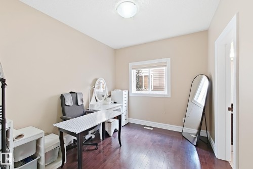 Room featuring rich wood-finish flooring, a window with white trim, and neutral-toned wall paint - 5931 12 Avenue Sw, Edmonton, AB - Indoor Photo Showing Office
