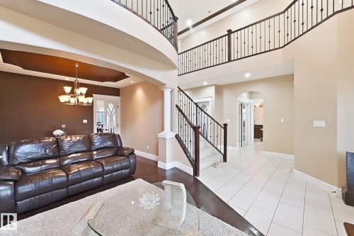 Grand entry featuring a curved staircase with wrought iron balusters and dark wood handrails - 5931 12 Avenue Sw, Edmonton, AB - Indoor