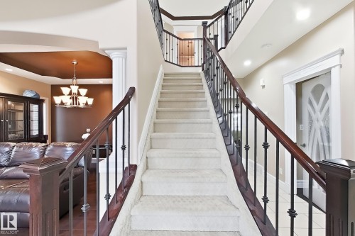 Curved staircase featuring wrought iron balusters and wood-finish handrails - 5931 12 Avenue Sw, Edmonton, AB - Indoor Photo Showing Other Room