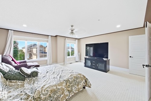 Spacious room with light neutral wall tones, white trim, and a contrasting brown crown molding - 5931 12 Avenue Sw, Edmonton, AB - Indoor Photo Showing Bedroom