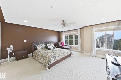 Spacious bedroom featuring neutral carpeting and a rich brown accent wall - 5931 12 Avenue Sw, Edmonton, AB - Indoor Photo Showing Bedroom