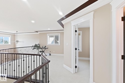 Upper level featuring dark wood-finish handrails with iron balusters, light-toned carpeting, and recessed lighting - 5931 12 Avenue Sw, Edmonton, AB - Indoor Photo Showing Other Room