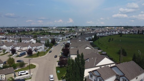 Residential area featuring a street, houses with shingled roofs, and a large green space - 5931 12 Avenue Sw, Edmonton, AB - Outdoor With View