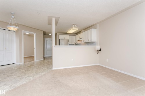 Open concept living space featuring neutral-toned carpeting - #413 237 Youville Dr E Nw, Edmonton, AB - Indoor Photo Showing Other Room