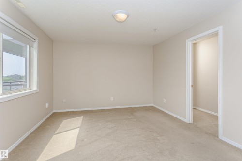Carpeted room featuring neutral wall tones and white baseboards - #413 237 Youville Dr E Nw, Edmonton, AB - Indoor Photo Showing Other Room