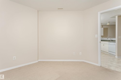 Neutral wall color with baseboard trim and carpet flooring - #413 237 Youville Dr E Nw, Edmonton, AB - Indoor Photo Showing Other Room