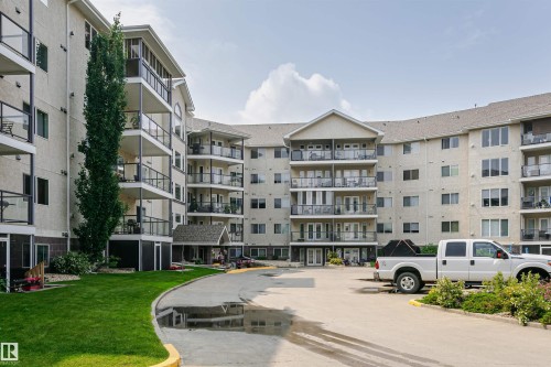 Multi-story residential building featuring a light-colored stucco exterior with multiple balconies - #413 237 Youville Dr E Nw, Edmonton, AB - Outdoor With Balcony With Facade
