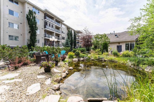 Landscaped grounds featuring a tranquil pond with natural rock edging - #413 237 Youville Dr E Nw, Edmonton, AB - Outdoor With Balcony