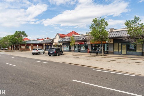Commercial streetscape featuring multiple storefronts with varied architectural styles - #413 237 Youville Dr E Nw, Edmonton, AB - Outdoor