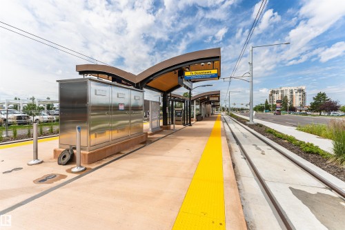 Modern light rail transit station featuring a covered platform, polished concrete flooring, and an information display - #413 237 Youville Dr E Nw, Edmonton, AB - Outdoor