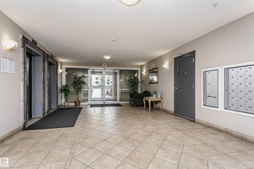 Entrance lobby featuring neutral-toned tile flooring, recessed overhead lighting, and wall sconces - #413 237 Youville Dr E Nw, Edmonton, AB - Indoor Photo Showing Other Room