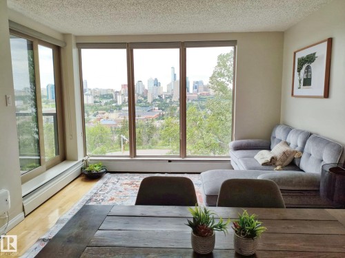 Expansive window wall with cityscape and tree-lined terrain - #509 10149 Saskatchewan Dr Nw, Edmonton, AB - Indoor Photo Showing Living Room
