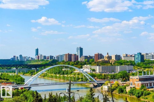 Urban skyline featuring high-rise buildings, a prominent arched bridge spanning a river, and a lush green river valley - #509 10149 Saskatchewan Dr Nw, Edmonton, AB - Outdoor With View