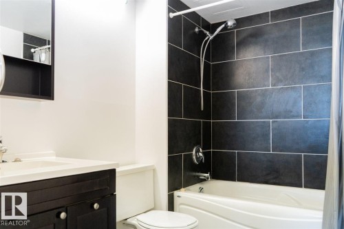 Bathroom featuring a dark wood-finish vanity with a white countertop and an integrated sink - #509 10149 Saskatchewan Dr Nw, Edmonton, AB - Indoor Photo Showing Bathroom