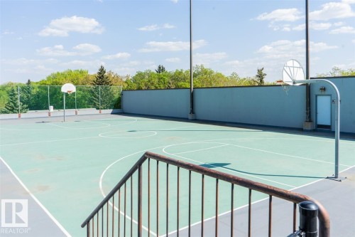 Rooftop basketball court featuring painted lines, two hoops with backboards, perimeter fencing, and a retaining wall - #509 10149 Saskatchewan Dr Nw, Edmonton, AB - Outdoor