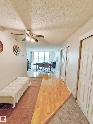 Bright main living area featuring large windows, wood-finish flooring, and multiple closet doors - #509 10149 Saskatchewan Dr Nw, Edmonton, AB - Indoor
