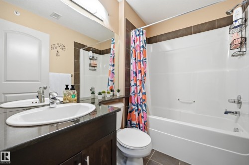 Bathroom featuring a dark wood-finish vanity with an undermount sink and dark countertop - #443 10121 80 Av Nw, Edmonton, AB - Indoor Photo Showing Bathroom