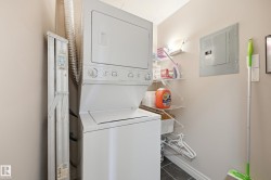 Dedicated laundry area featuring a stackable washer and dryer, tile flooring, and integrated shelving - 
