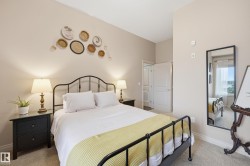 Spacious room featuring neutral-toned walls, plush carpeting, and an arched ceiling detail - 
