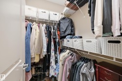 Walk-in closet featuring wire shelving, multiple hanging rods, and integrated storage solutions - 