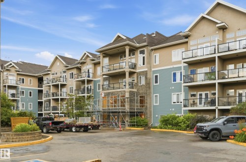 Multi-story residential building featuring diverse exterior finishes including stone, siding, and stucco - #443 10121 80 Av Nw, Edmonton, AB - Outdoor With Balcony With Facade