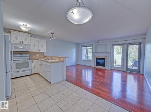 #3 10 Woodcrest Ln, Fort Saskatchewan, AB - Indoor Photo Showing Kitchen With Fireplace
