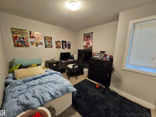Carpeted room with light grey walls, a single window with white blinds, and a flush-mount ceiling light fixture - 13309 104 Street Nw, Edmonton, AB - Indoor Photo Showing Bedroom