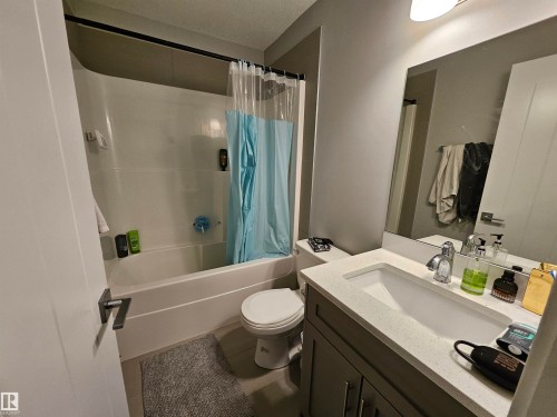 Bathroom featuring a white bathtub, toilet, and a vanity with a light-colored countertop - 13309 104 Street Nw, Edmonton, AB - Indoor Photo Showing Bathroom