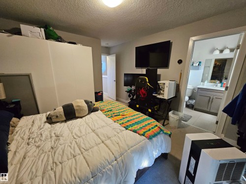 Bedroom featuring neutral wall paint, carpet flooring, a ceiling-mounted light fixture, and a white door frame - 13309 104 Street Nw, Edmonton, AB - Indoor Photo Showing Bedroom