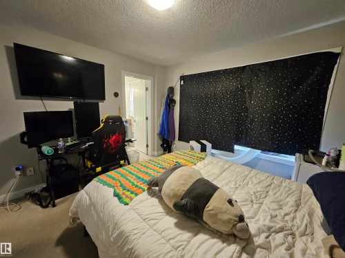 Spacious bedroom featuring light neutral wall paint and textured ceiling - 13309 104 Street Nw, Edmonton, AB - Indoor Photo Showing Bedroom