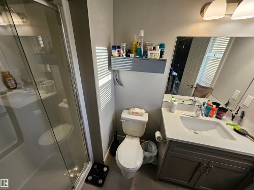 Full bathroom featuring a glass-enclosed shower, a vanity with a light-toned countertop, and an integrated sink with a chrome faucet - 13309 104 Street Nw, Edmonton, AB - Indoor Photo Showing Bathroom