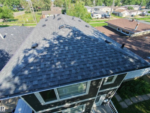 Multi-toned asphalt shingle roof featuring multiple roof vents and dark brown exterior siding with white trim - 13309 104 Street Nw, Edmonton, AB - Outdoor