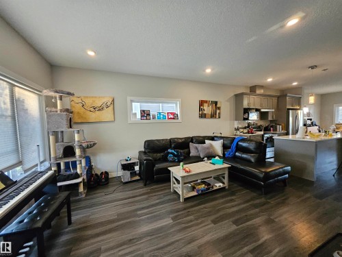Open-concept living area featuring wood-finish flooring, recessed lighting, and large windows - 13309 104 Street Nw, Edmonton, AB - Indoor