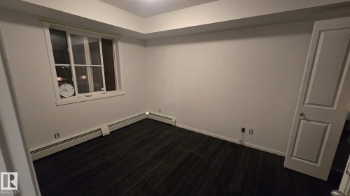 Bright room featuring an expansive window, neutral wall tones, and dark textured flooring - 1510 Watt Drive Southwest, Edmonton, AB - Indoor Photo Showing Other Room