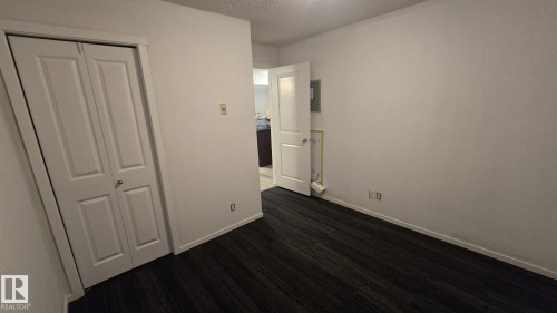 Room featuring dark wood-finish flooring, white walls, and white trim - 1510 Watt Drive Southwest, Edmonton, AB - Indoor Photo Showing Other Room