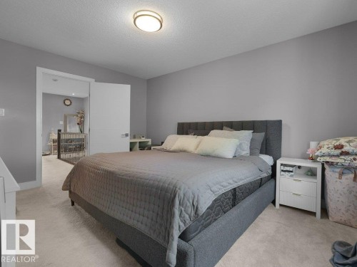 Carpeted bedroom featuring neutral grey walls and a flush-mount ceiling light fixture - 7909 105 Avenue Nw, Edmonton, AB - Indoor Photo Showing Bedroom