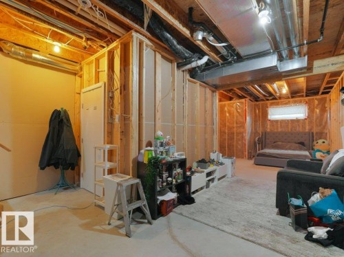 Unfinished basement space featuring exposed wood framing, concrete flooring, visible HVAC ductwork, and overhead lighting - 7909 105 Avenue Nw, Edmonton, AB - Indoor Photo Showing Basement