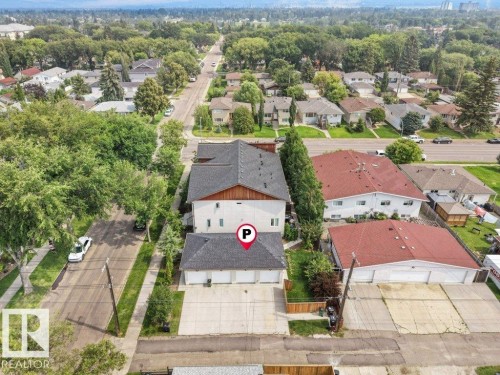 Charming residential property featuring a distinctive two-story design with a dark gray pitched roof, white exterior siding, and wood-finish accents - 7909 105 Avenue Nw, Edmonton, AB - Outdoor With View