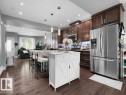 Open-concept kitchen featuring dark wood-finish flooring, recessed lighting, a kitchen island with pendant lights, dark wood cabinetry, and stainless steel appliances - 7909 105 Avenue Nw, Edmonton, AB  - Indoor Photo Showing Kitchen With Upgraded Kitchen 