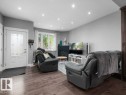 Living area featuring wood-finish flooring, recessed lighting, a white framed window with decorative curtains, and a white entry door with frosted glass panels - 7909 105 Avenue Nw, Edmonton, AB  - Indoor 