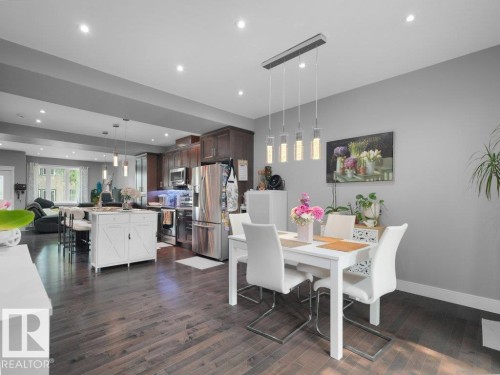 Open-concept living space featuring wood-finish flooring, recessed lighting, and a contemporary dining area with a linear pendant fixture - 7909 105 Avenue Nw, Edmonton, AB - Indoor Photo Showing Dining Room