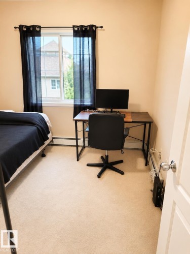 Window-equipped room featuring light neutral wall paint and plush carpeting - #202 16715 100 Av Nw, Edmonton, AB - Indoor