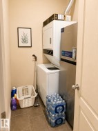 Dedicated laundry closet featuring a stacked washer and dryer, tile flooring, and a solid core interior door - 