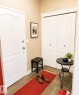 Entryway featuring a paneled door with brushed nickel hardware, tan wall paint, and brown tile flooring - #202 16715 100 Av Nw, Edmonton, AB  - Indoor Photo Showing Other Room 