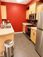 Galley kitchen featuring light wood cabinetry, light-toned countertops, and stainless-steel appliances - 