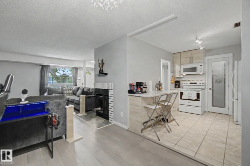 Kitchen with light-toned cabinetry, white appliances, and a tiled backsplash - #39 3111 142 Av Nw, Edmonton, AB - Indoor