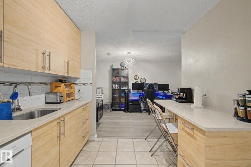 Kitchen featuring light wood-finish cabinetry, light-toned countertops, and a white tile backsplash - #39 3111 142 Av Nw, Edmonton, AB - Indoor Photo Showing Kitchen