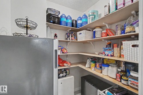 Corner pantry featuring multiple levels of light wood shelving - #39 3111 142 Av Nw, Edmonton, AB - Indoor With Storage